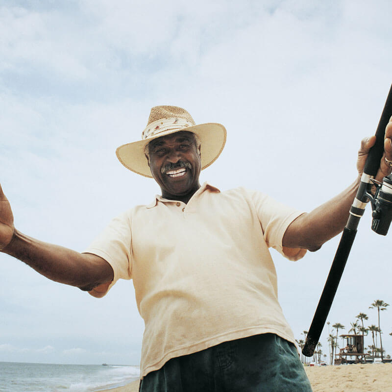 man with hat on and fishing pole